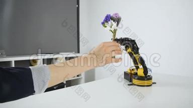 机器人<strong>手臂</strong>给女孩一束花。 <strong>智能机械</strong>手实验。 工业机器人模型。